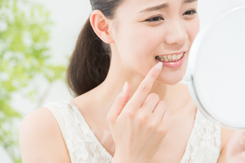 手鏡で前歯を確認する女性